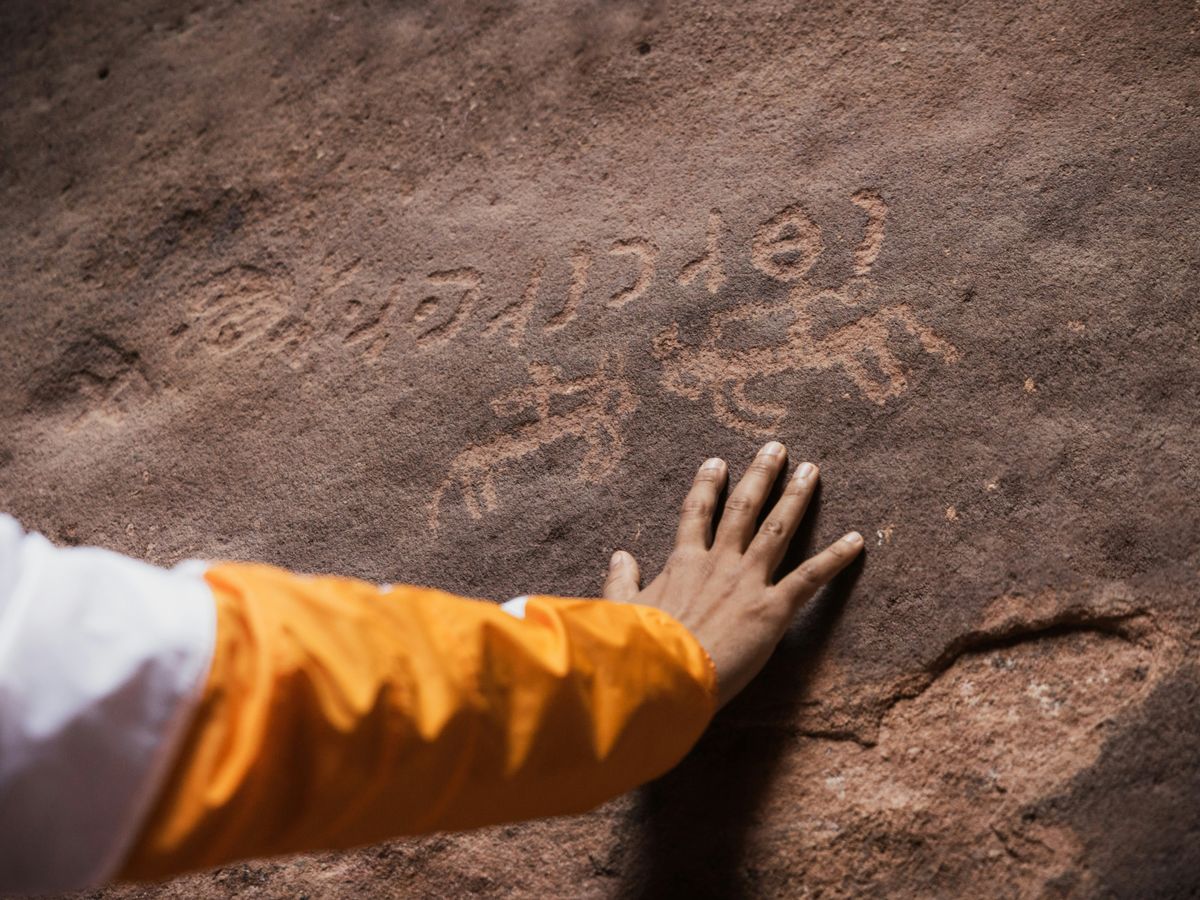 a person with their hand on a rock