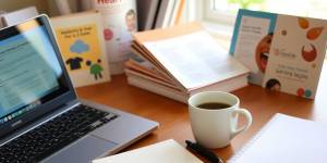 A workspace with laptop, coffee, and health materials.