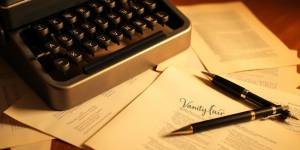 Vintage typewriter with scattered pages and a pen.