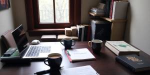 A writer's desk with a laptop and coffee cup.