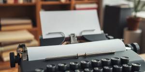 Typewriter with paper in a cozy workspace setting.