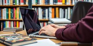 Person typing on a laptop with scientific materials nearby.